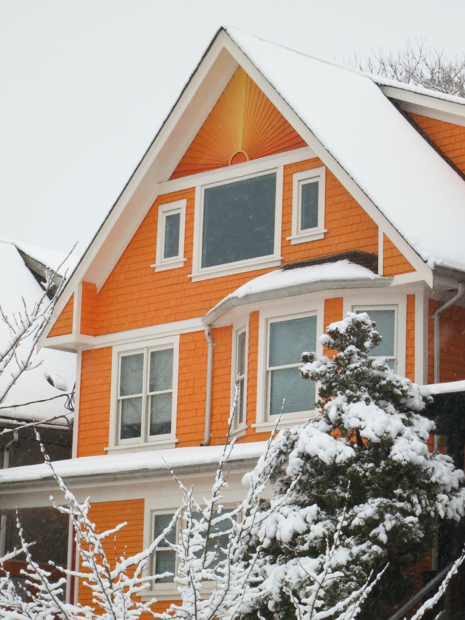 Snow-covered roof edges and eavestroughs on a Vancouver home, where eavestrough cleaning in winter matters